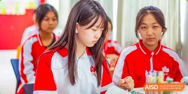 A female student from Kunming Concord College of Sino-Canada (CCSC) looks down while seated in a classroom.