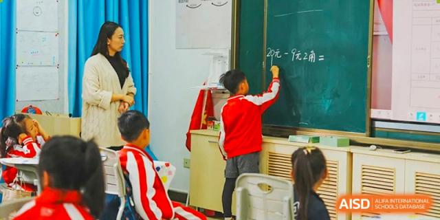 A student from Kunming Concord College of Sino-Canada (CCSC) writes on a blackboard in a classroom.
