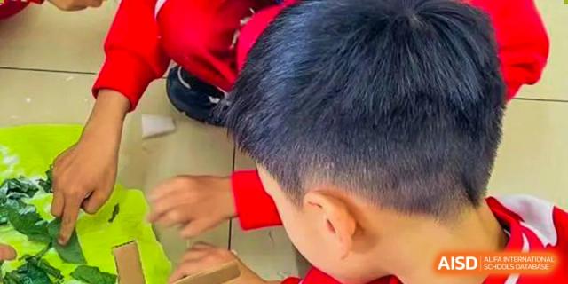The back of a young student's head from Kunming Concord College of Sino-Canada (CCSC) is shown as they focus on their work.