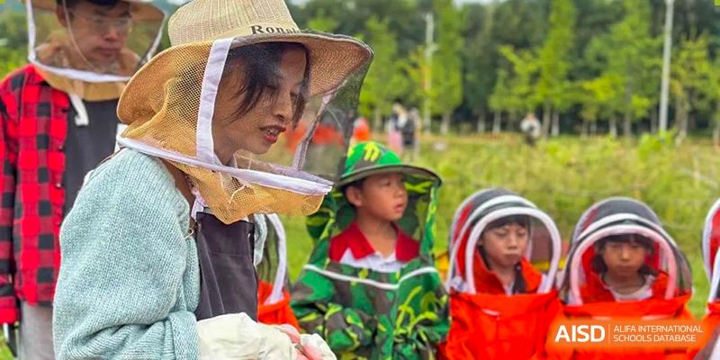 A close-up shot of a young child at an event hosted by Kunming Concord College of Sino-Canada (CCSC), wearing a green hat and a jacket.