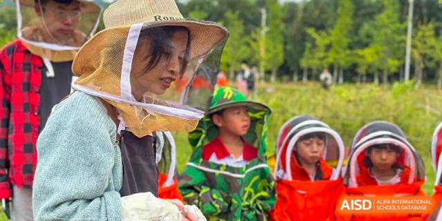 A close-up shot of a young child at an event hosted by Kunming Concord College of Sino-Canada (CCSC), wearing a green hat and a jacket.