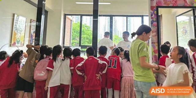 A group of students from Kunming Concord College of Sino-Canada (CCSC) wearing red uniforms and posing for a photo with a teacher.