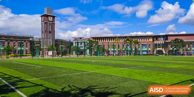 A wide shot of the school building and sports field at Kunming Concord College of Sino-Canada (CCSC).