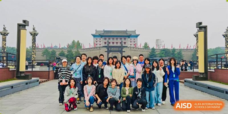 A large group of students and teachers from Kunming Concord College of Sino-Canada (CCSC) pose for a group photo outdoors.
