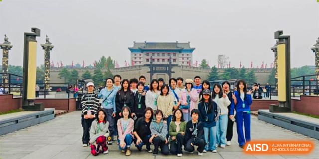 A large group of students and teachers from Kunming Concord College of Sino-Canada (CCSC) pose for a group photo outdoors.