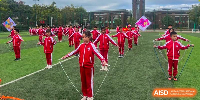 Students from Kunming Concord College of Sino-Canada (CCSC) hold hands and play a game on the sports field.