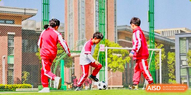 A student from Kunming Concord College of Sino-Canada (CCSC) plays soccer on the school field.