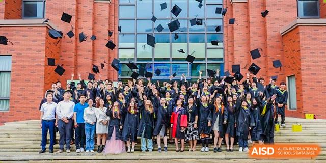 Graduating students from Shanghai International High School of BANZ celebrating by throwing their caps in the air.