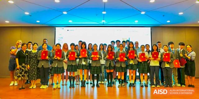 A group of students from Shanghai International High School of BANZ in matching uniforms, holding awards or certificates.
