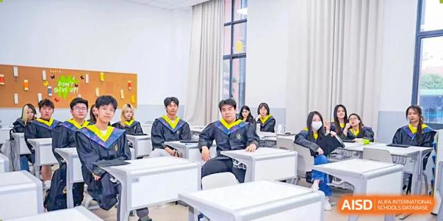 Two students from Shanghai International High School of BANZ sitting at a desk in a classroom.