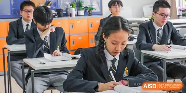 A student at Shanghai International High School of BANZ diligently takes notes in a classroom.