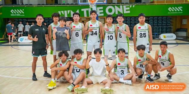 A group of students from Shanghai International High School of BANZ posing for a photo on a basketball court.
