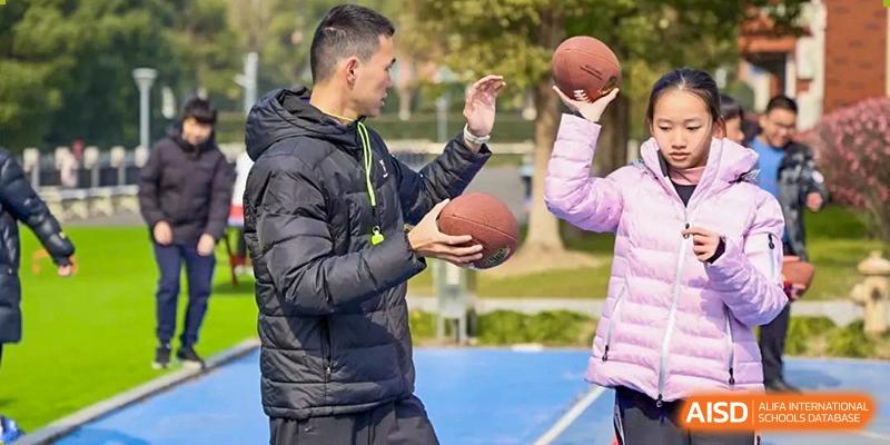 Two students from Shanghai International High School of BANZ playing with a football.