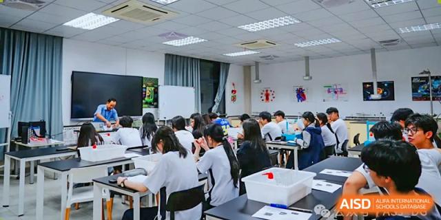 Students from The Affiliated School of JNU for Hong Kong & Macau Students (ASJ Dongguan) are working on a project in a classroom.
