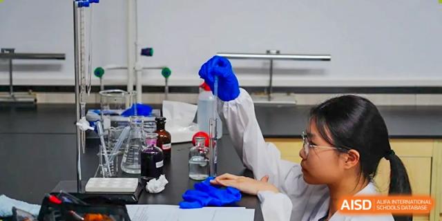 A student from The Affiliated School of JNU for Hong Kong & Macau Students (ASJ Dongguan) is working on a science experiment in a lab.