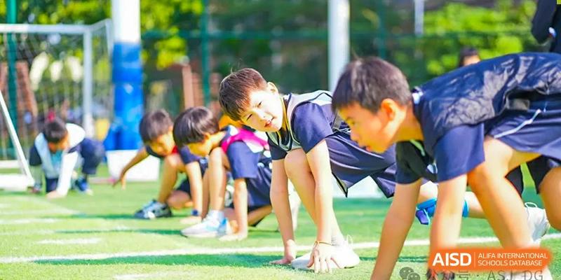 Students from The Affiliated School of JNU for Hong Kong & Macau Students (ASJ Dongguan) are participating in an outdoor sports event.