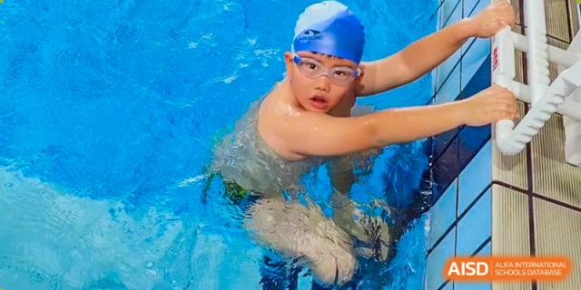 A student from The Affiliated School of JNU for Hong Kong & Macau Students (ASJ Dongguan) is swimming.