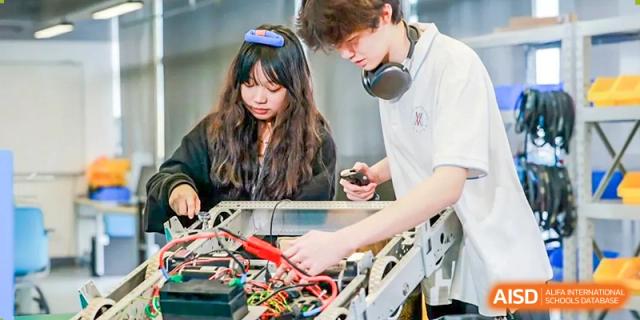 Two students, a male and a female, are working on a robotic project at Vanke Meisha Academy.