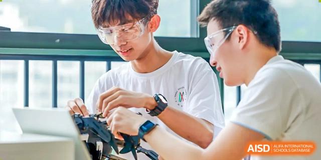 Two male students wearing safety goggles are working on a science project together at Vanke Meisha Academy.
