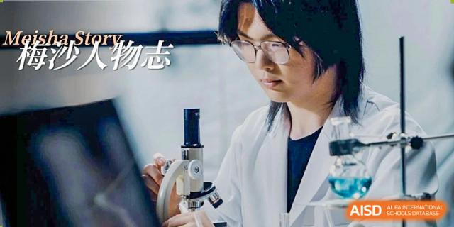 A male student wearing safety glasses is looking into a microscope at Vanke Meisha Academy.