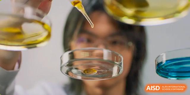 A person in the background with blurred vision while another person holds a petri dish at Vanke Meisha Academy.