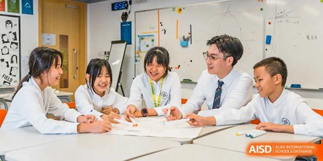 A group of students and a teacher are working collaboratively on a project at Vanke Meisha Academy.