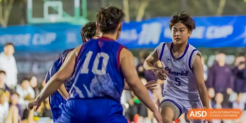 A basketball player wearing a blue jersey with the number 10 is dribbling during a game at Vanke Meisha Academy.