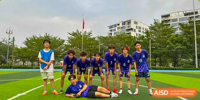 A team of male soccer players stands on the field at Vanke Meisha Academy.