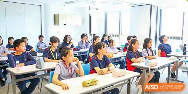 Students sitting at desks and listening in a classroom at Yew Chung International School of Chongqing