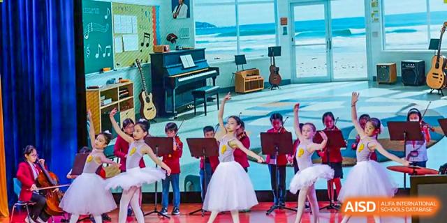 Young students in ballet and musical attire performing on a stage at Yew Chung International School of Chongqing