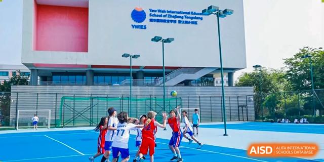 Students playing basketball on an outdoor court at Yew Chung International School of Chongqing