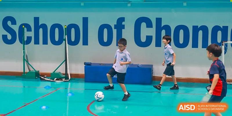 A boy playing soccer in a gymnasium at Yew Chung International School of Chongqing