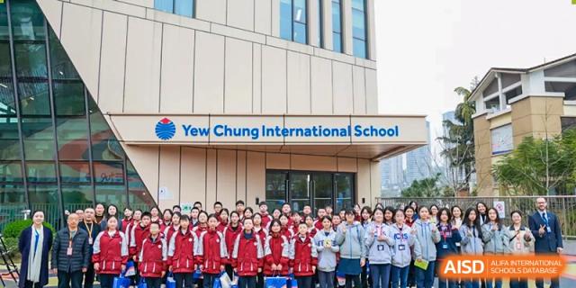 A large group of students and teachers standing together for a photo outside a school building at Yew Chung International School of Chongqing
