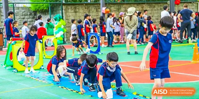 Students crawling through a tunnel during a sports activity at Yew Chung International School of Chongqing