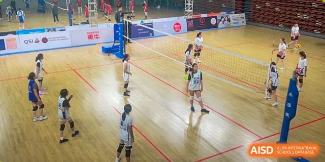 Students playing volleyball in a gymnasium at Yew Chung International School of Chongqing