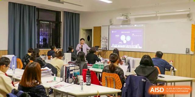 Students attending a lecture or presentation in a classroom with a projector screen at Yiwu International Academy.