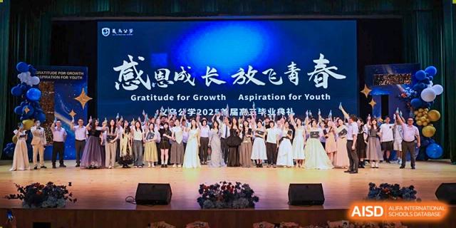 Students from Yiwu International Academy dressed in formal attire for a stage performance with a banner reading "Gratitude for Growth."