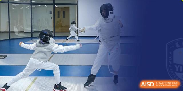 A student practicing fencing, dressed in full protective gear, an activity offered at Yiwu International Academy.