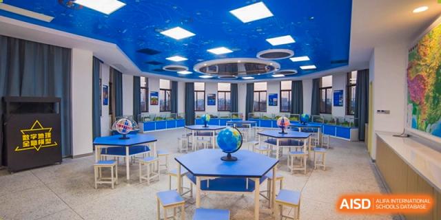 A bright, modern circular classroom or media center with a globe on a table at Yiwu International Academy.