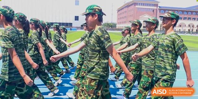 Students in camouflage uniforms marching during a drill or physical education session at Yiwu International Academy.