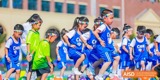 Students from Yiwu International Academy playing basketball or participating in a sports drill in blue uniforms.