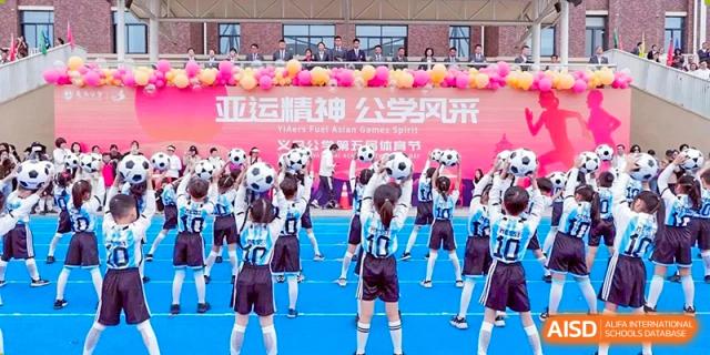 A group of students from Yiwu International Academy performing a choreographed dance or cheer routine with soccer balls.