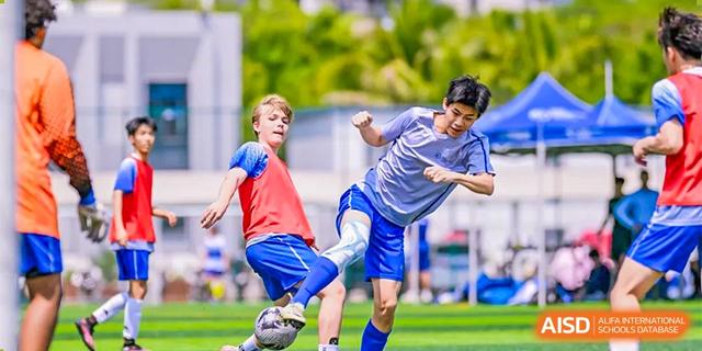 Two students aggressively challenging each other for the soccer ball during a practice or game at BASIS International School Hangzhou (BIHZ).
