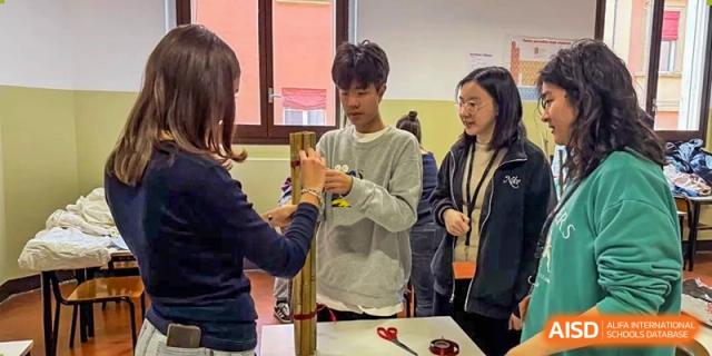 Students from World Leading Schools Association collaborating on a hands-on project with cardboard tubes and scissors.