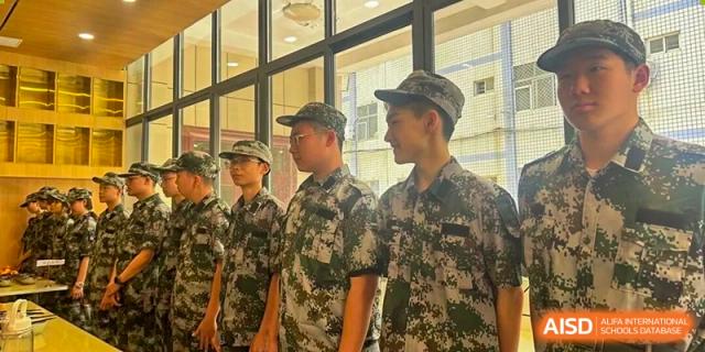 Zhengzhou No.9 High School International Department students and instructors in camouflage uniforms, possibly during military training or a school event.