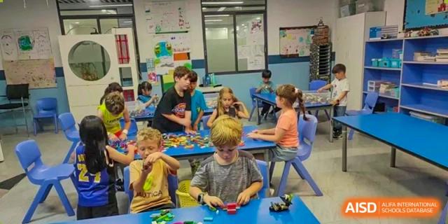 Young students engaged in hands-on activities, playing with colorful blocks and toys in a bright classroom at QSI International School of Dongguan.