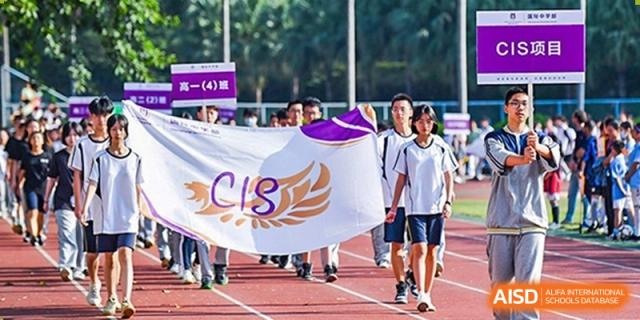 Guangzhou Huamei International School students in uniform marching on a running track, holding a banner for CIS (Council of International Schools).
