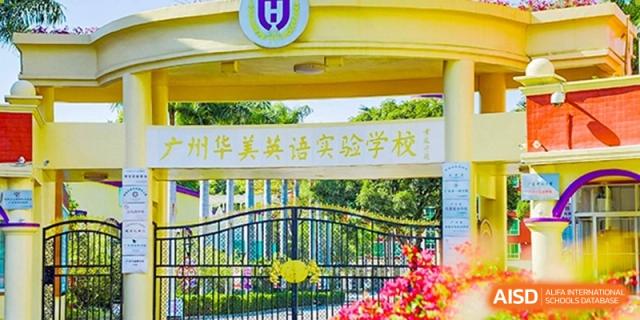 A yellow sign at Guangzhou Huamei International School featuring the school's name in Chinese characters, surrounded by vibrant red and pink flowers.