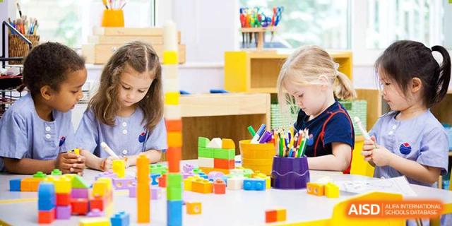 Young children playing with colorful building blocks and art supplies in a classroom at Yew Chung International School of Beijing.
