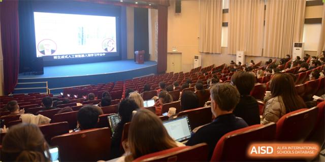 A view of the school auditorium filled with students working on laptops during a lecture or presentation at Yew Chung International School of Beijing.
